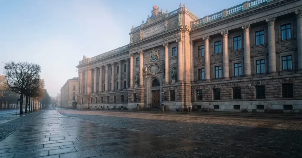 Stenfasad på en statlig byggnad i Stockholm vid gryning, höga pelare och ett tomt torg framför — svenska blackjack regler
